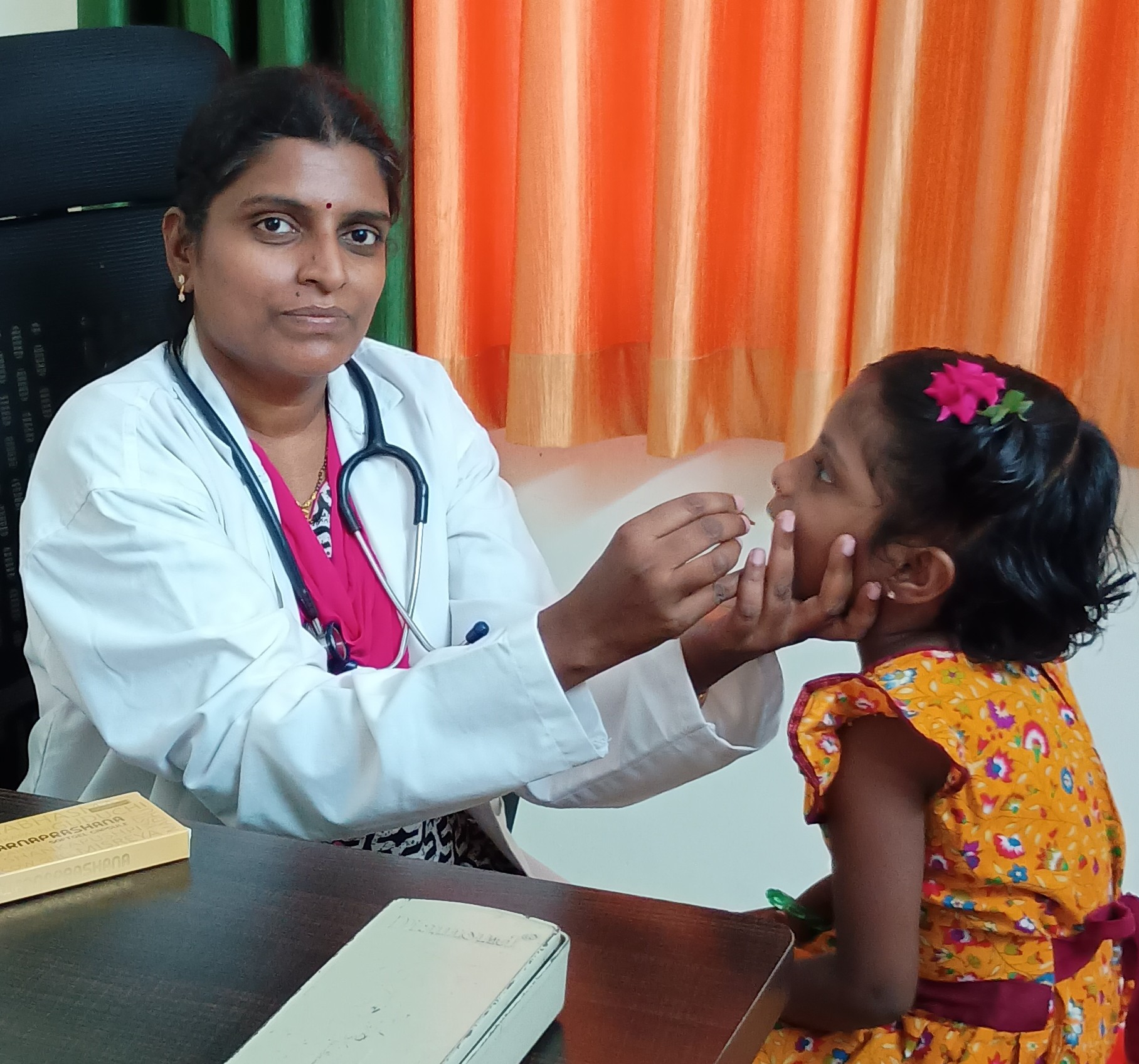Our Best Ayurvedic doctor administering swarna prashana to child in our ayurvedic clinic Shree Aayurbhava Ayurveda Hospital in Vijayawada